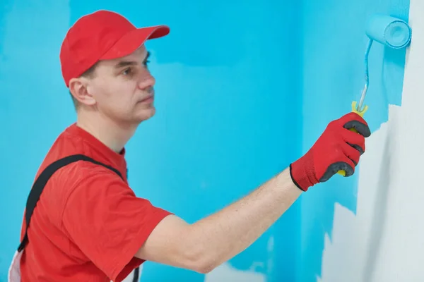 Trabajador de pintor con superficie de pared de pintura de rodillos en color — Foto de Stock