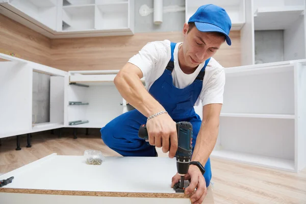 Instalación de cocina. Trabajador montando muebles — Foto de Stock