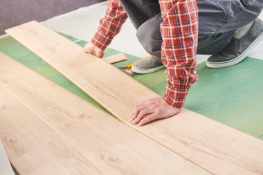 Ev tadilatında kaplama döşemesi döşeyen işçiler