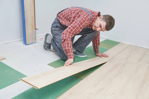 Trabajador que pone laminado revestimiento de suelo en la renovación del hogar — Foto de Stock