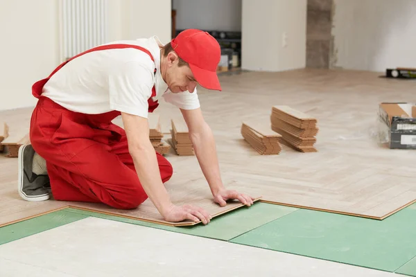 Arbetare som lägger laminatgolv vid renovering i hemmet — Stockfoto