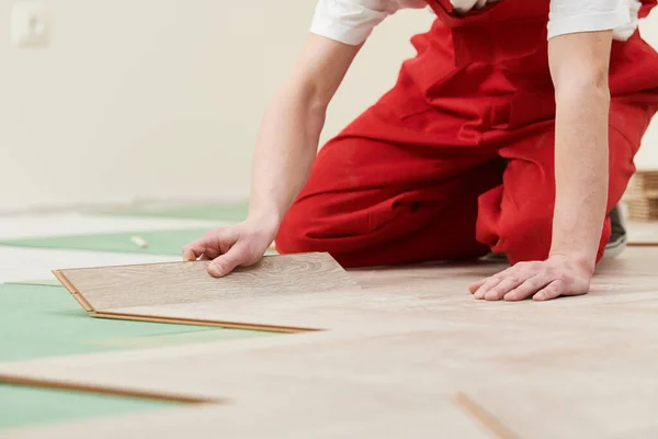 Lavoratore posa pavimento in laminato rivestimento a casa ristrutturazione — Foto Stock