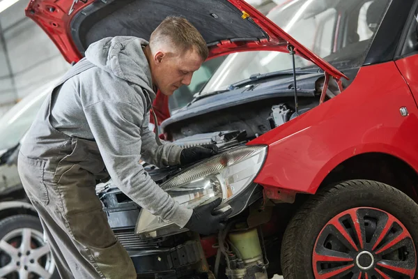 Automatisk service. Tekniker som monterar en bilstrålkastare. reparation av karosseri för försäkring — Stockfoto