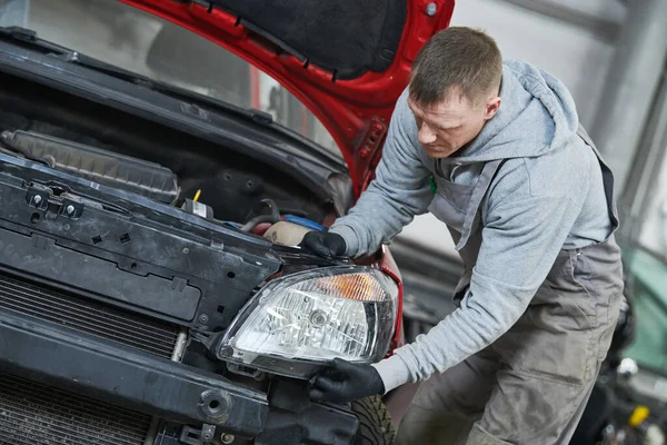 Auto-Service. Techniker beim Zusammenbau einer Autoscheinwerfer-Lampe. Karosseriereparatur für die Versicherung — Stockfoto