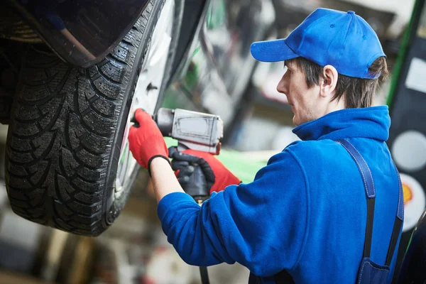 Auto-Service. Arbeiter schrauben an einem Autorad. Pannenhilfe oder Reifenwechsel — Stockfoto