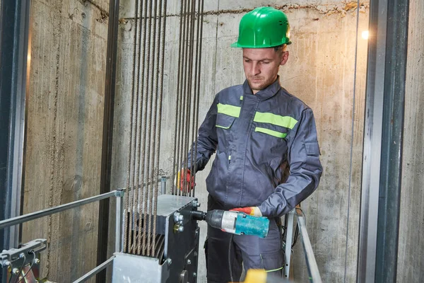 Lift machinist repairing elevator in lift shaft — Stock Photo, Image