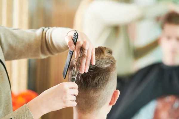 Corte de cabelo do jovem. Cabeleireiro na barbearia — Fotografia de Stock