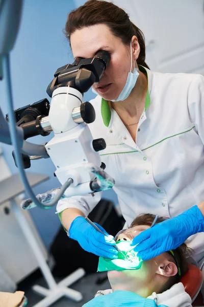 Dentist doing medical treatment male patient with microscope — Stock Photo, Image