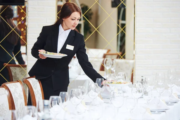 Restaurante camarera sirviendo mesa con comida — Foto de Stock