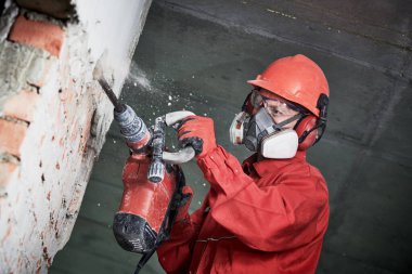 worker with demolition hammer breaking interior wall clipart