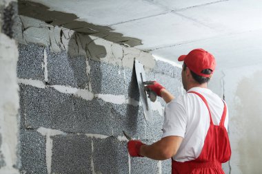 Sıva işçisi köşeleri örgü ile koruyor. inşa teknolojisi