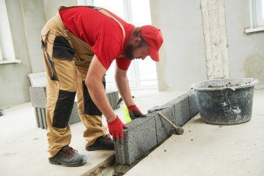 Seramoni beton bloklarıyla çalışan tuğla ustası. Duvarlama