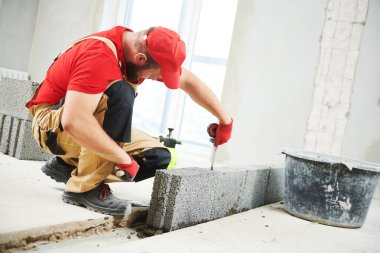 Seramoni beton bloklarıyla çalışan tuğla ustası. Duvarlama