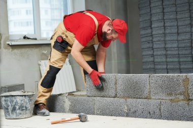 Seramoni beton bloklarıyla çalışan tuğla ustası. Duvarlama