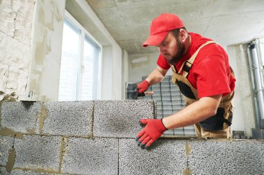 Seramoni beton bloklarıyla çalışan tuğla ustası. Duvarlama