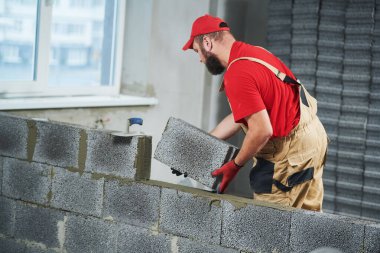 Seramoni beton bloklarıyla çalışan tuğla ustası. Duvarlama