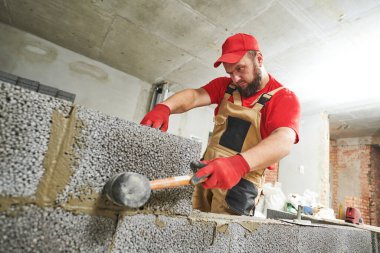 Seramoni beton bloklarıyla çalışan tuğla ustası. Duvarlama