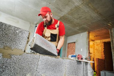 Seramoni beton bloklarıyla çalışan tuğla ustası. Duvarlama