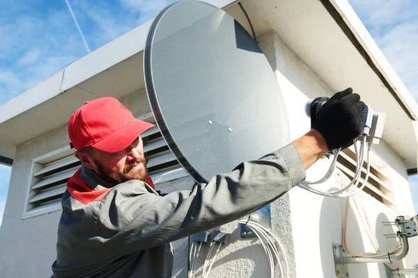 Service worker installing and fitting satellite antenna dish for cable TV — Stock Photo, Image