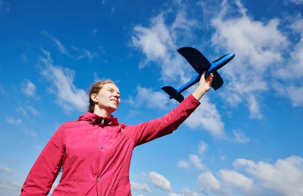 Girl playing with airplane. blue sky background. Travel and vacation concept — Stock Photo, Image