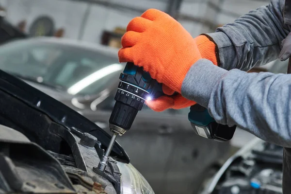 Taller de reparación de automóviles. Trabajador montando carrocería del coche — Foto de Stock