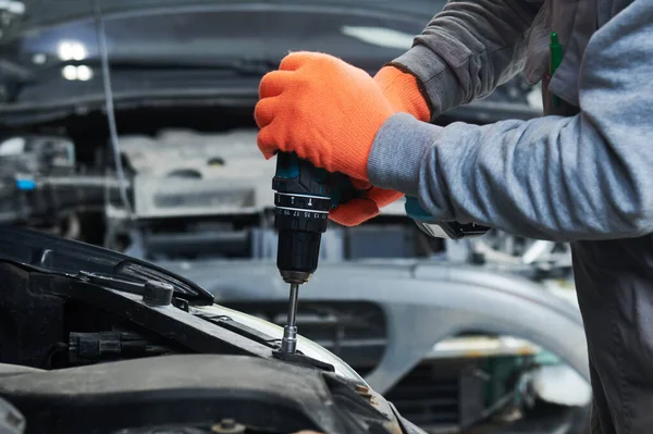 Automobile repair shop. Worker assembling car body — Stock Photo, Image