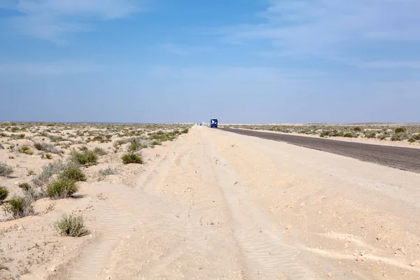 旅游客车在荒无人烟的公路上行驶在盐干湖上 从阿尔及利亚到突尼斯的公路上行驶在Chott Jerid盐滩上 — 图库照片
