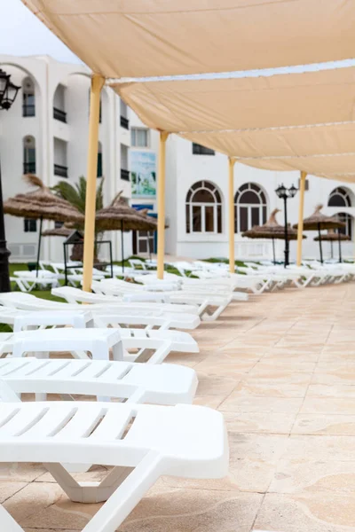 旅馆区的阳台上有很多空的白色塑料日光浴床 由于考拉病毒而取消了假日 — 图库照片