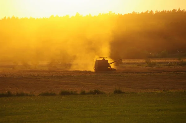 Harvester against hot orange sunset background