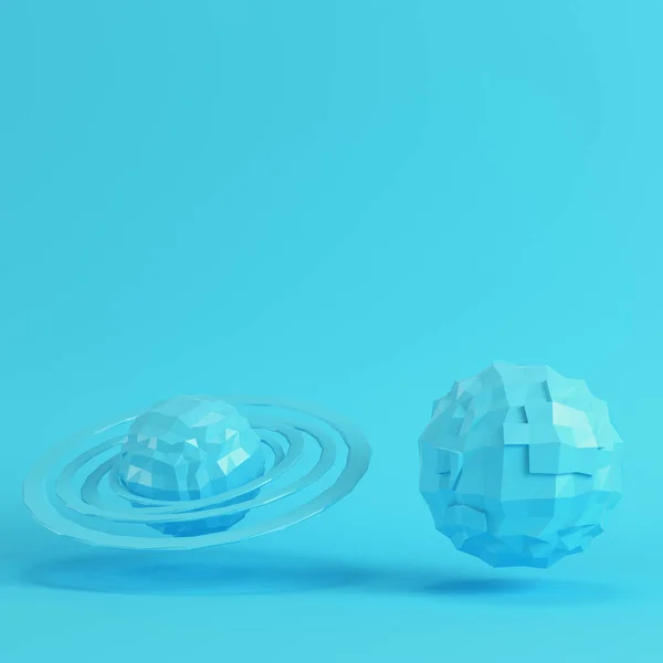 两个蓝色低聚行星在明亮的蓝色背景上柔和的颜色 简约理念 免版税图库照片
