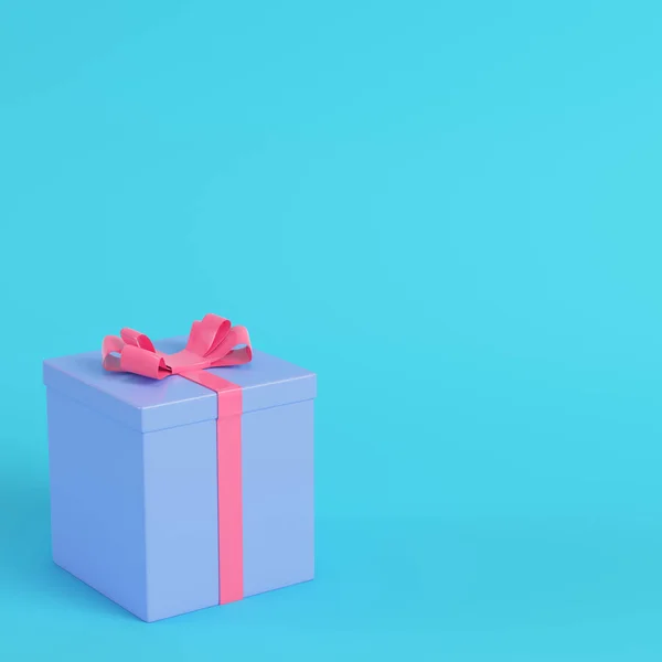 粉红色礼品盒与丝带弓在明亮的蓝色背景在柔和的颜色 极简主义概念 — 图库照片
