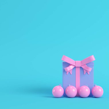 Pembe hediye kutusu ile şerit yay ve Noel top parlak mavi arka plan pastel renkler üzerinde. Minimalizm kavramı. 3D render