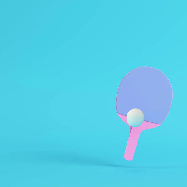 Raket ping pong merah muda dengan bola pada latar belakang biru cerah di pas — Stok Foto
