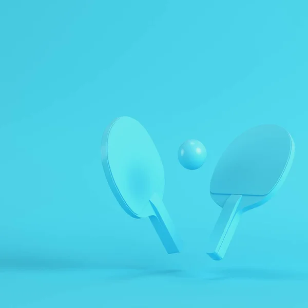 Raquetas de ping pong con bola sobre fondo azul brillante en pastel —  Fotos de Stock