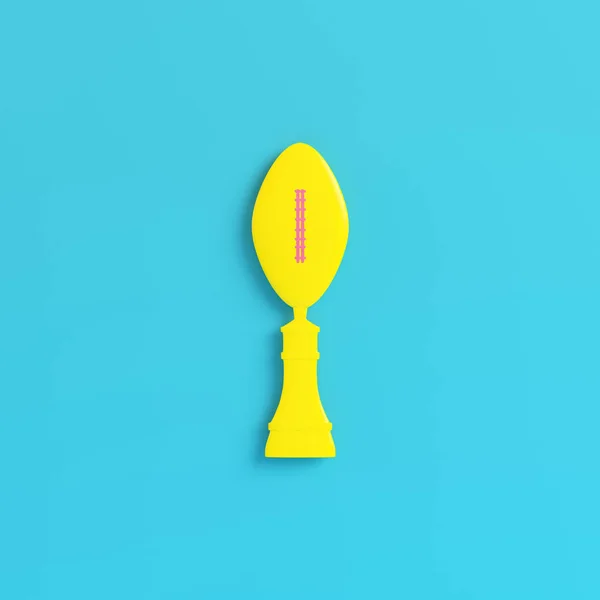 Troféu de bola de futebol americano amarelo no fundo azul brilhante — Fotografia de Stock