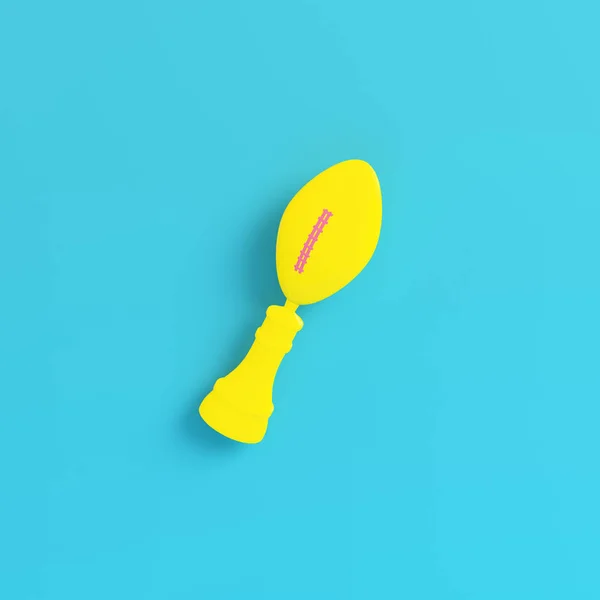 Yellow american football ball throphy on bright blue background — Stock Photo, Image