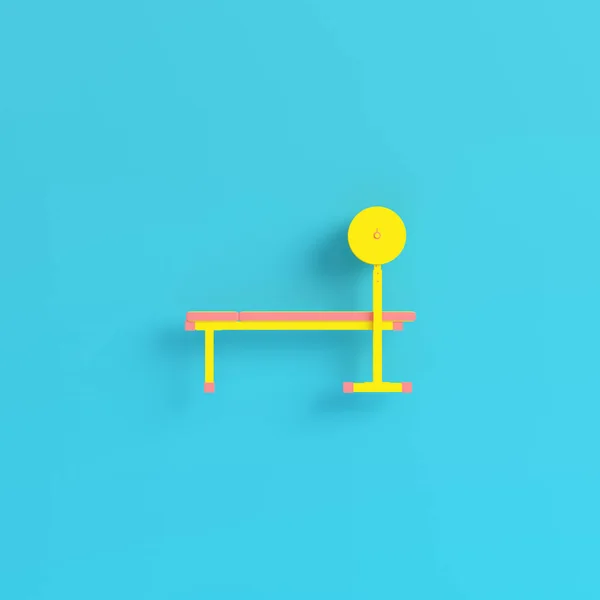 Gelbe Langhantel auf Bank auf hellblauem Hintergrund in Pastellfarben — Stockfoto