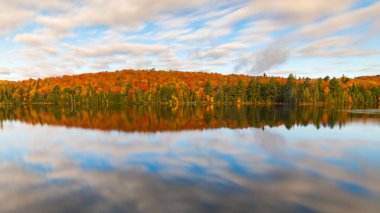 Renkli sonbahar gölün üzerine düşünceler ağaçları. Uzun pozlama görüntü bulanık bulutlar ve ipek su Algonquin Park, Ontario, Kanada. Gevşeme, Doğa ve sonbahar Temalar.