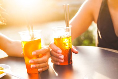 İki kadın bir yaz kokteyl günbatımında açık. İçecekler tutan elleri kadar yakın ve bir barda bir Nehri yanındaki toasting, sahne aydınlatma günbatımında. Yaşam tarzı ve dostluk kavramları