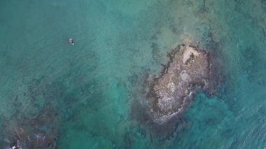 Bir tekne ve deniz berrak suda güneyinde İtalya ile küçük bir kayalık ada hava üstten görünüm. Güzel doğa görüntülemek, yaz aylarında mükemmel seyahat hedef.