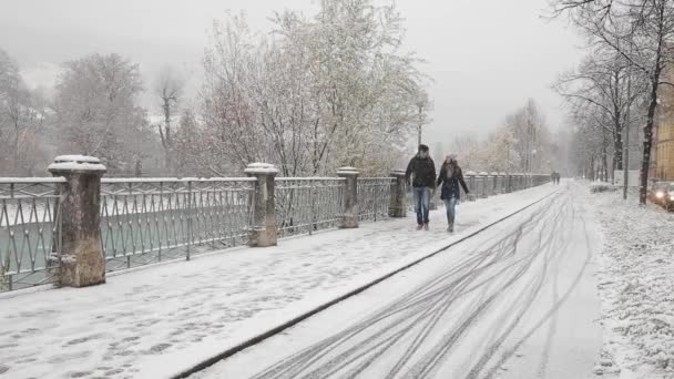 雪の降る冬の日に オーストリアのインスブルックで歩くカップル チロルの首都と白歩行者の歩道を散歩を楽しむ人々 の寒さ 天気と生活の概念 — ストック動画