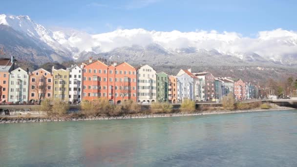背景に オーストリアのインスブルック観 雪に覆われた山々 と川沿いのカラフルな家 冬チロルの首都の晴れた日 アーキテクチャおよび旅行の概念 — ストック動画