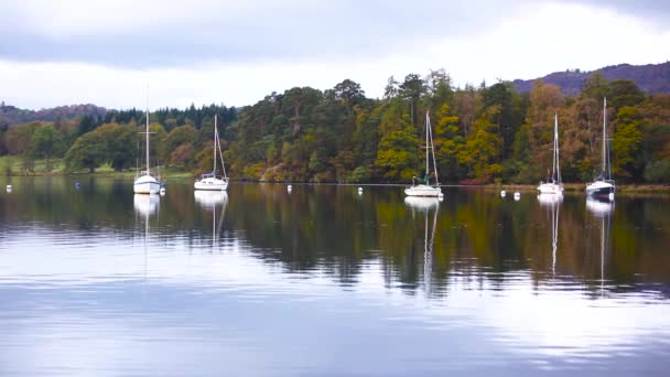 在英国湖区的水上航行的船只和树木的倒影 船停泊在码头旁边 上面有林地 秋天颜色和心情 旅行和自然概念 — 图库视频影像