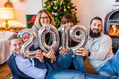 Mutlu insanlar, yeni yıl 2019 kutlama arkadaş. Gülümseyen kadın ve erkekler, gülüyor ve 2019 balon holding'yeni yıl kutlamaları oturum açın. Yaşam tarzı ve tatil
