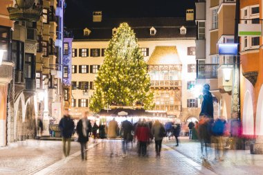 Noel pazarı ve geceleri İnnsbruck ağaç. Uzun pozlama görüntü bulanık insanlar, ışık süslemeleri, ünlü Ambras Kalesi ve büyük bir ağaç. Tatil ve bayram kavramları