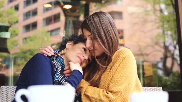 喫茶店レズビアンのカップル 人の若い女性は抱きしめること 話して 一緒にコーヒーを飲んでいるし お互いにキスをします 実質の人々 と率直な状況 同性愛および生活様式の概念 — ストック動画