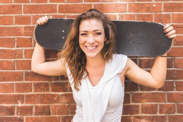 Chica Sosteniendo Monopatín Sonriendo Retrato Contra Una Pared Mujer Joven —  Fotos de Stock