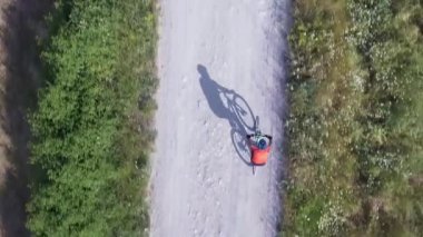 Adam dağ bisikleti ile kırsal yolda Bisiklete binme. Havadan görünümü açık spor pratik eğitim ve having fun, gölge tarafında, bir binici. Sağlıklı yaşam tarzı da önemli bir kavramdır