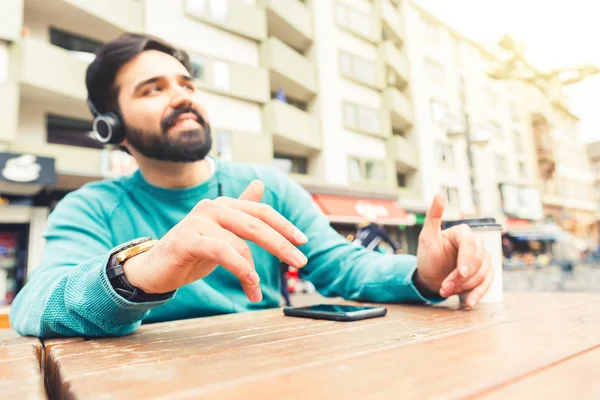 손으로 헤드폰으로 음악을 남자는 도시에 테이블에 Rithm 라이프 스타일 개념을 — 스톡 사진
