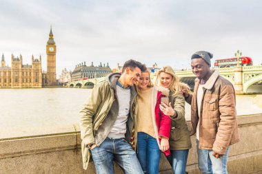 Londra'da Smartphone kullanarak mutlu çok ırklı arkadaş grubu